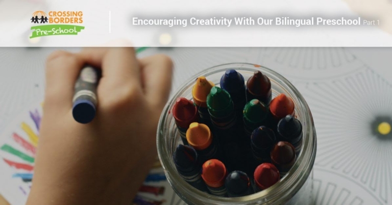 A child's hand colors with a crayon, while a jar filled with vibrant crayons stands nearby, ready for creative exploration.