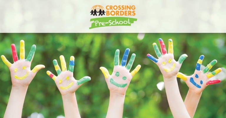 Colorfully painted hands with smiley faces are raised, symbolizing creativity and joy in children's art activities.