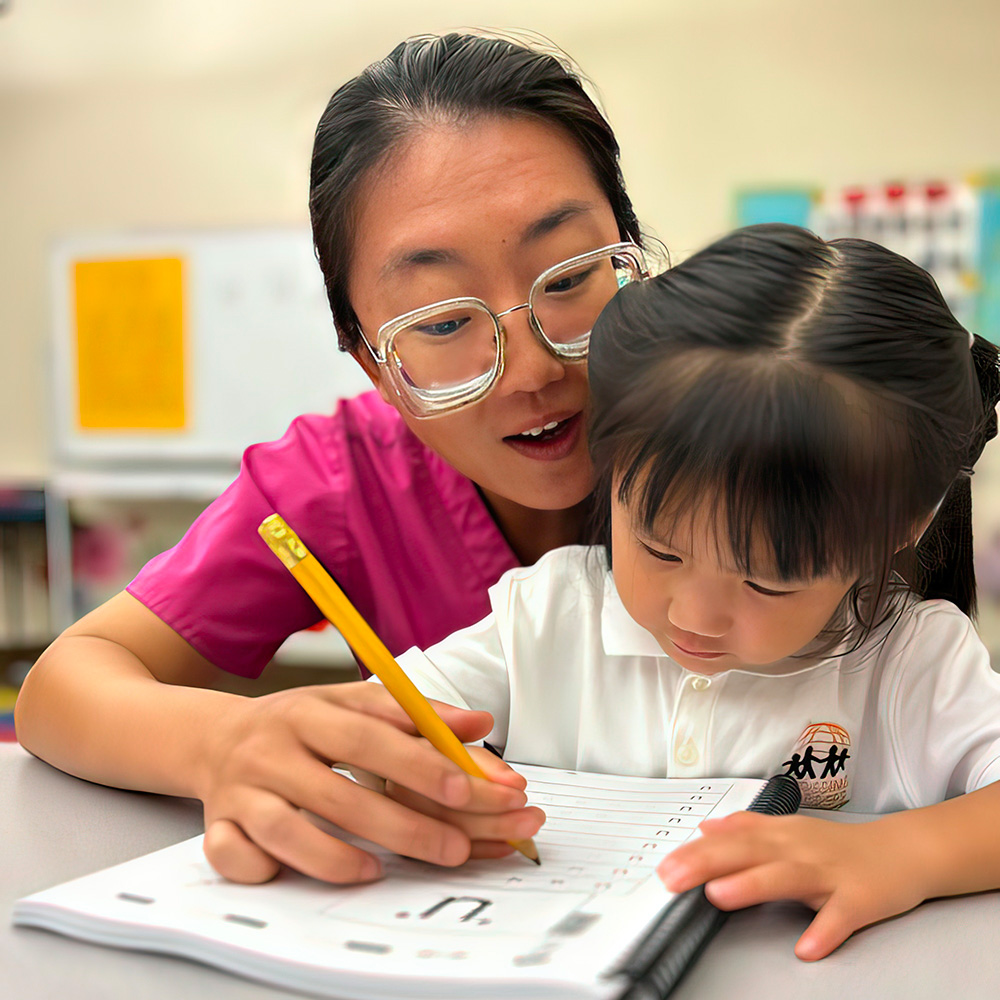 A teacher helps a young girl with her writing, fostering a supportive learning environment in the classroom.